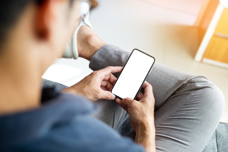 Momak drži mobilni telefon u rukama