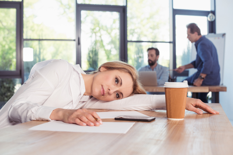 Žena se oseća umorno tokom radnog vremena u kancelariji