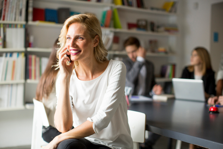 Uspešna poslovna žena razgovara telefonom u kancelariji